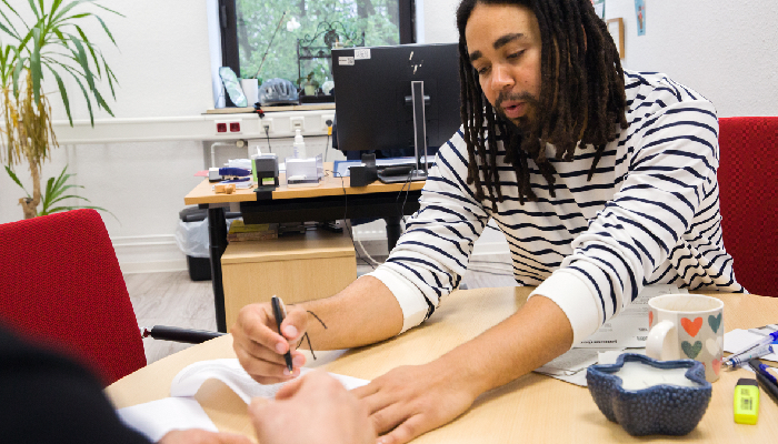 Hamza Ellakoui, Seniorenberater im Bezirksrathaus Kalk, im Gespräch mit einer Ratsuchenden. Foto: Roland Meurer